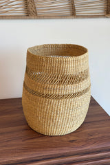 Made Brave planter basket holding a potted plant on a wood floor