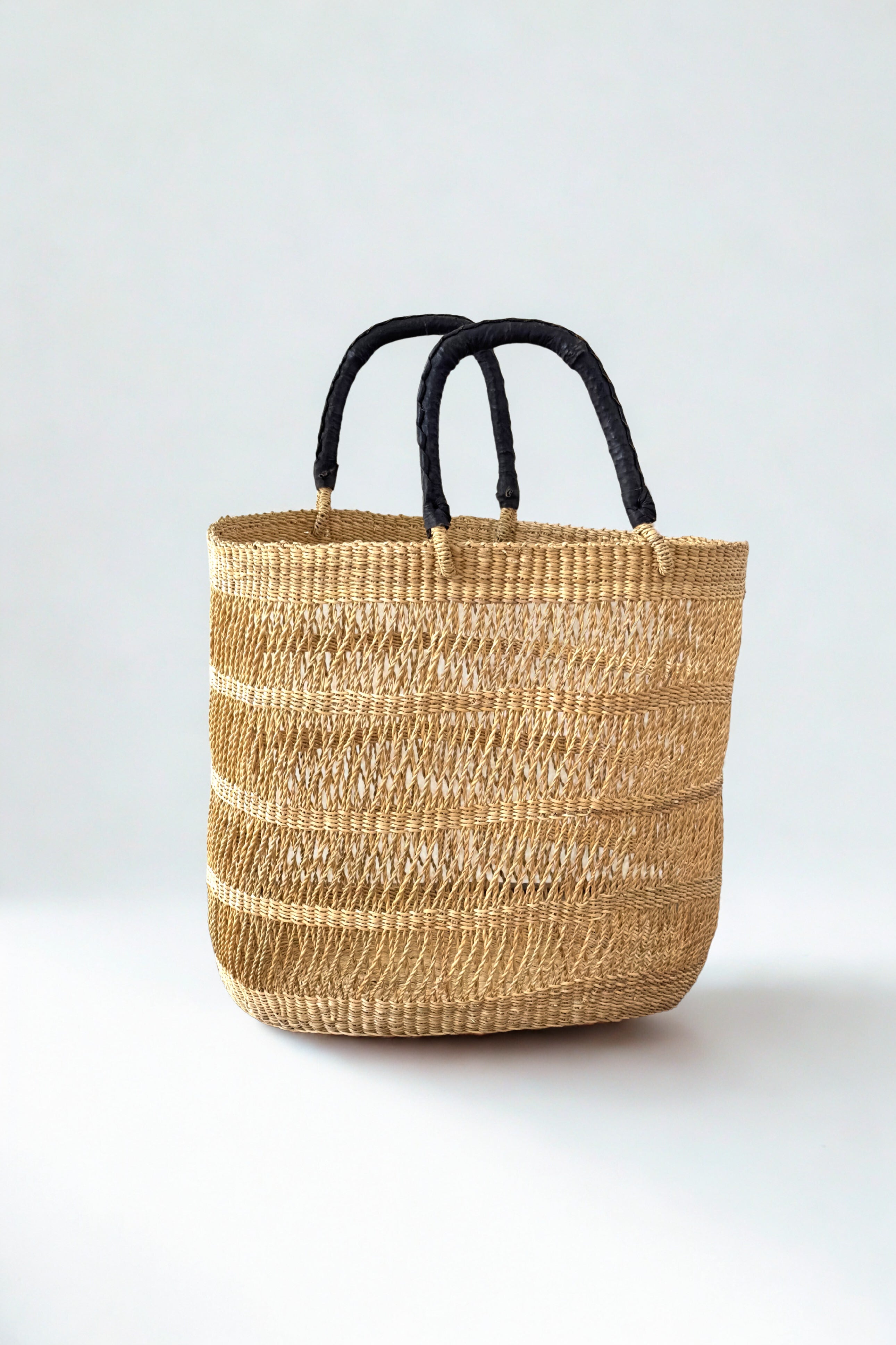 String basket tote in natural elephant grass with black leather handles Made Brave