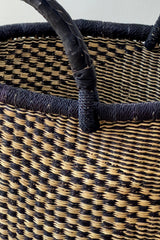 Made Brave checkerboard Bolga basket styled on a floor near a chair