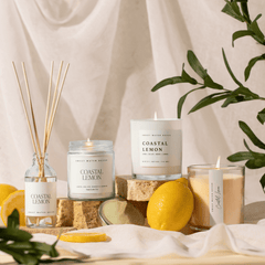 Coastal Lemon candle burning clear glass jar gold lid warm glow