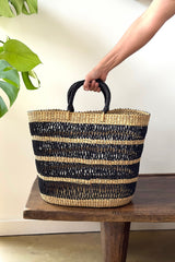 Made Brave string basket tote styled on a table with black leather handles visible