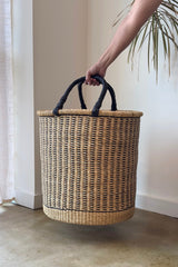 Made Brave raffia laundry hamper styled next to a washing machine