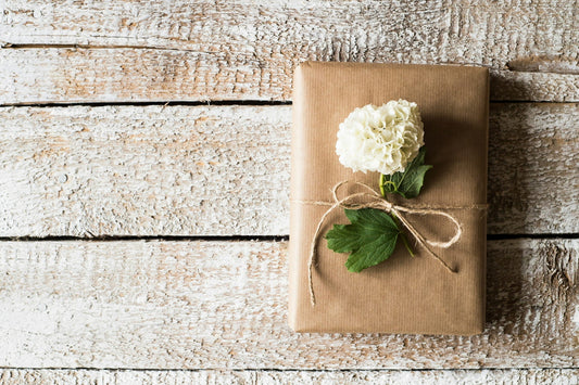 Thoughtful Mother's Day gift wrapped in kraft paper with white hydrangea — unique gifts for mom 2026 Made Brave