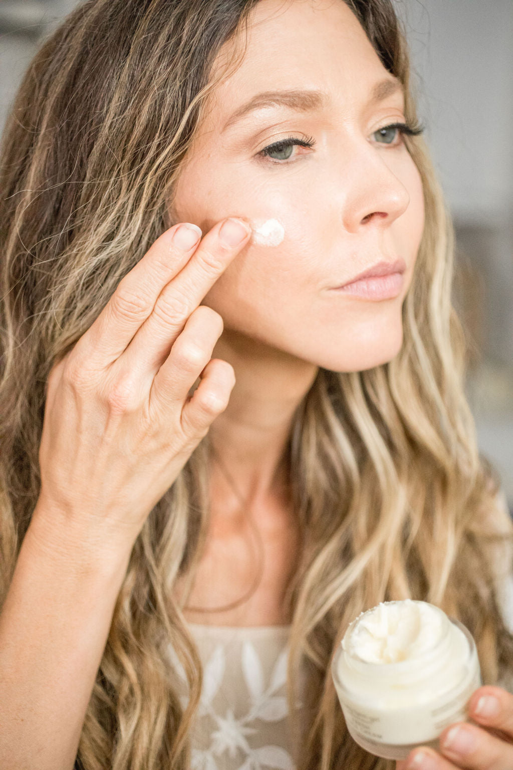 Woman applying tallow anti-aging face cream for radiant mature skin